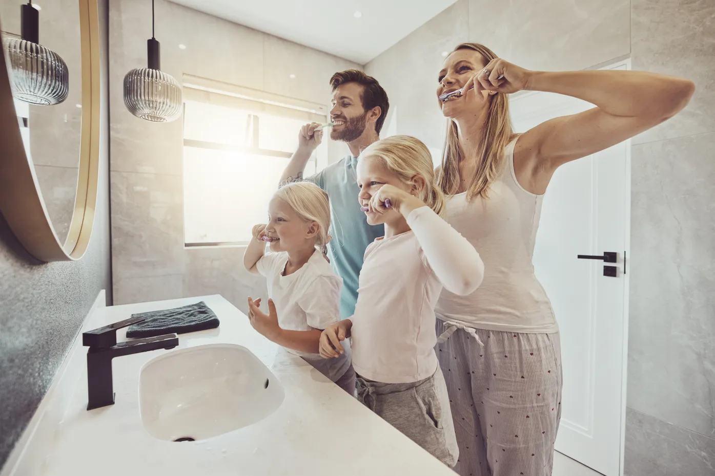 Family in the bathroom brushing teeth after build on your lot project completion